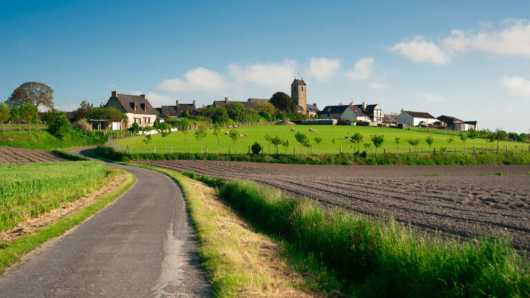 A rural road winding through the countryside of Normandy
