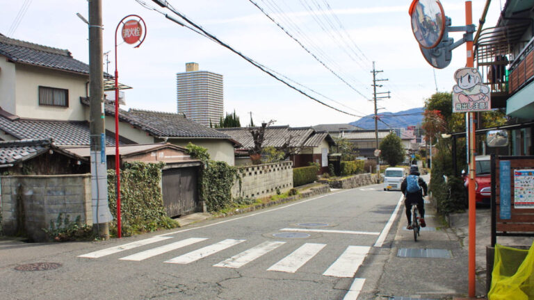 Panoramic view of the peaceful street in Japan with a man cycling on the side