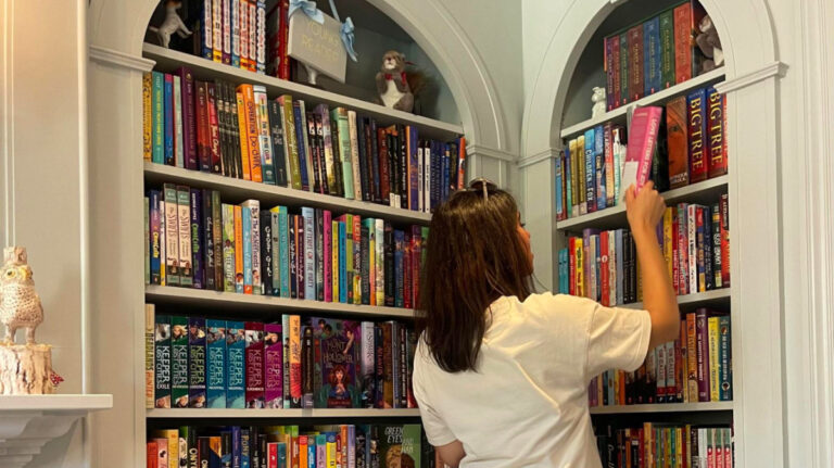 Author Claudicet Pena looking at books in Beacon Hills Books & Cafe