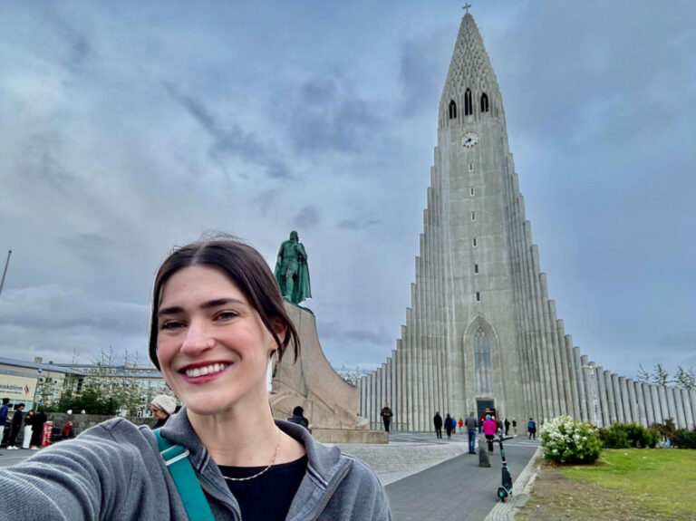 Author Betty taking a selfie backdropped by Hallgrímskirkja in Reykjavík