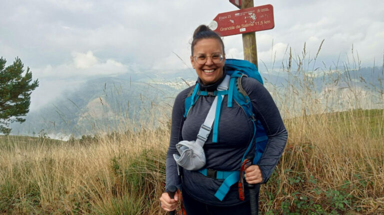 Author Catherine standing at the direction sign at Camino Primitivo on a foggy day