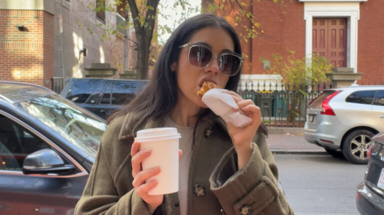 Author Claudicet eating a pastry and enjoying a coffee in Boston