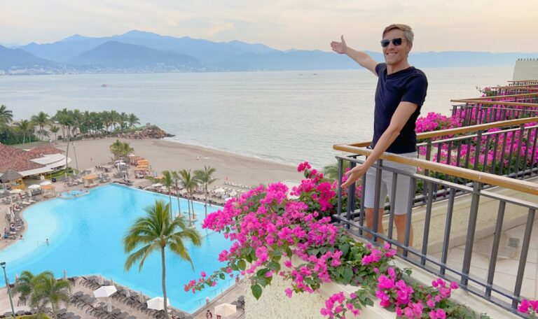 Nate on a balcony with the overlooking view of the pool and ocean in Marina Vallarta