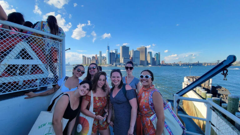 Author Niamh and friends poses on the deck of the Staten Island Ferry with the New York City skyline in the background
