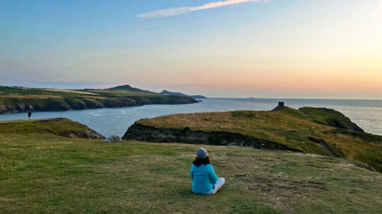 The author Ruthie Walters, admiring the scenic view in Pembrokeshire Coast National Park at sunset
