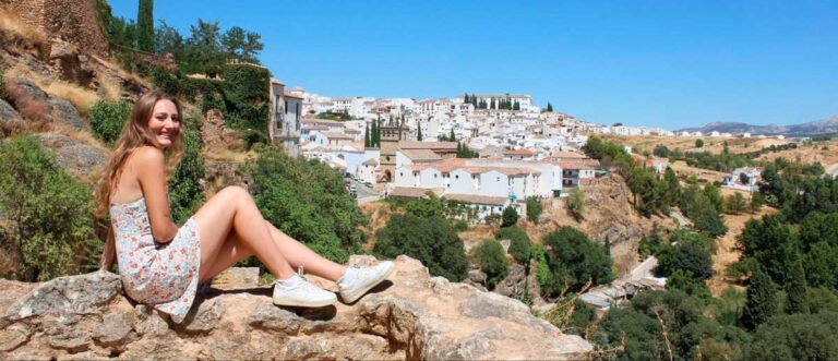 The author Sky Ariella posing for a photo and the city of Ronda on her background