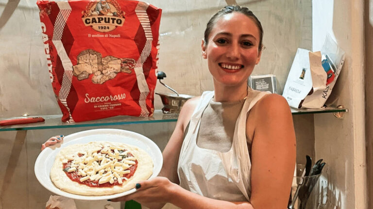 The author Sky Ariella, showing her pizza from the pizza-making class in Naples