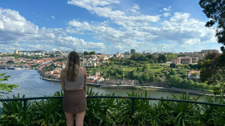 Author Sky stands at the Miradouro da Vitória viewpoint in Porto, gazing out at the views