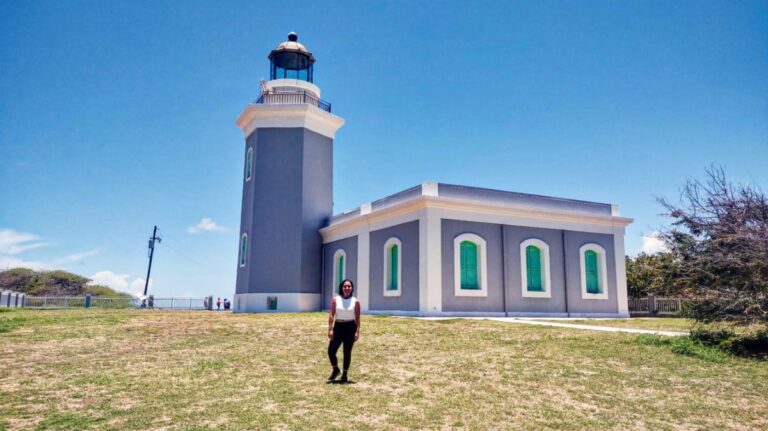 The author Vanessa Ramos, posing in front of the purple exterior of Cabo Rojo Lighthouse