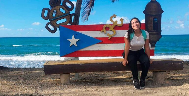 The author sitting on a chair with the Puerto Rican flag at Litoral Guaniquilla