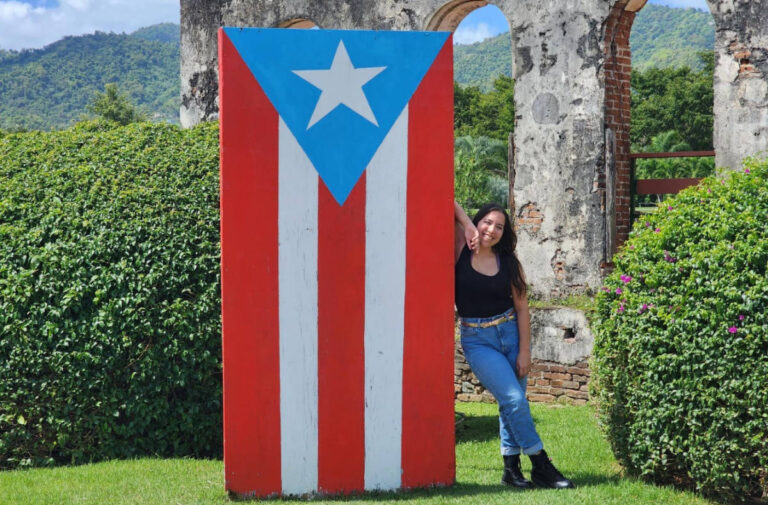 The author, Vanessa Ramos posing with the flag of Puerto Rico