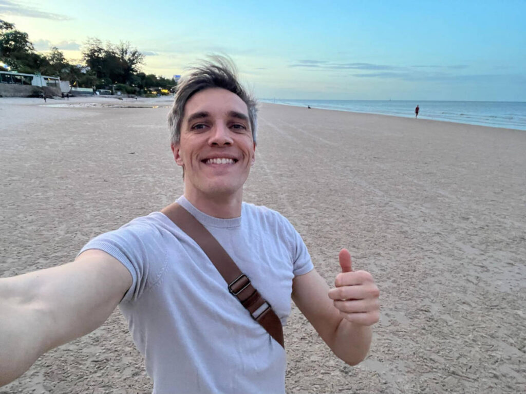 The author, Nate Hake smiling for a selfie in an empty beach in Hua Hin