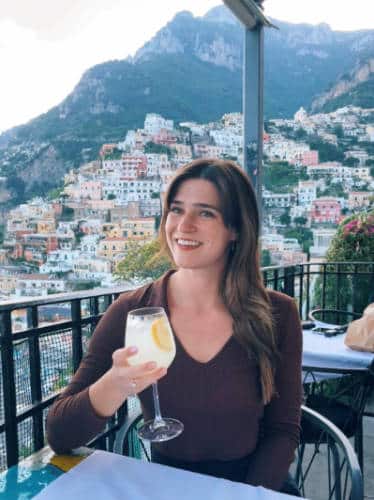 Betty Hurd holding a wine glass while smiling in Positano, Italy