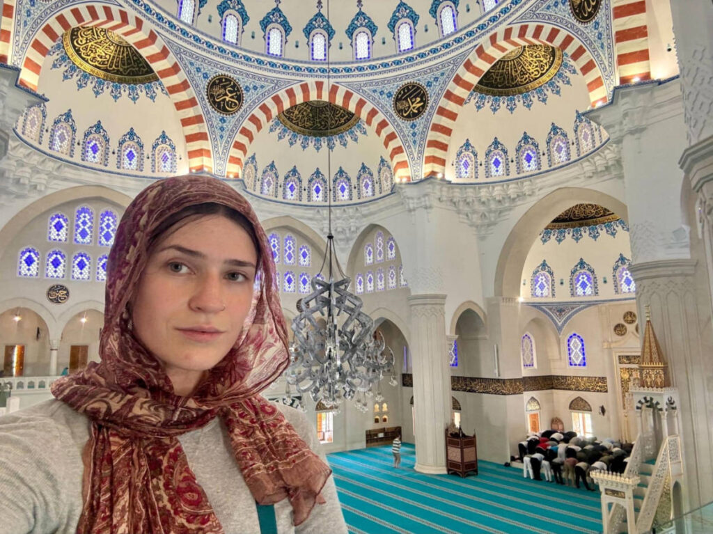 The author Betty Hurd, covering her hair with a scarf inside the mosque