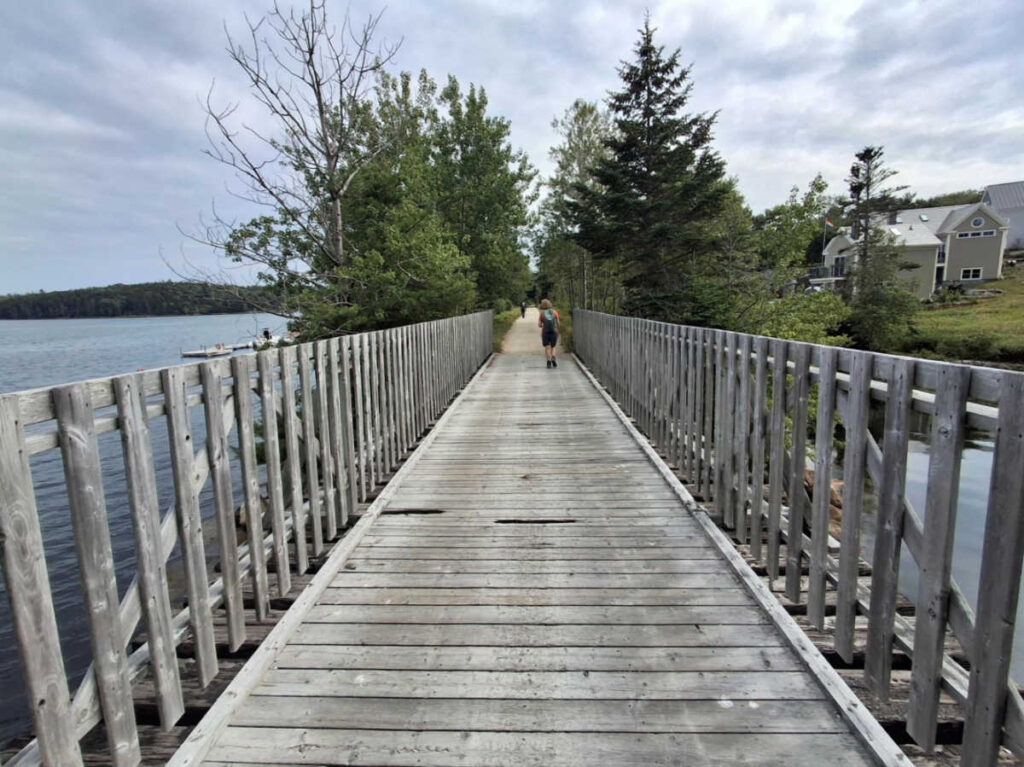 People walking the boardwalk leading to Mahone Bay