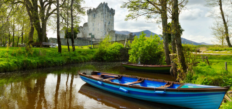 A boat is docked in front of a castle in Killarney