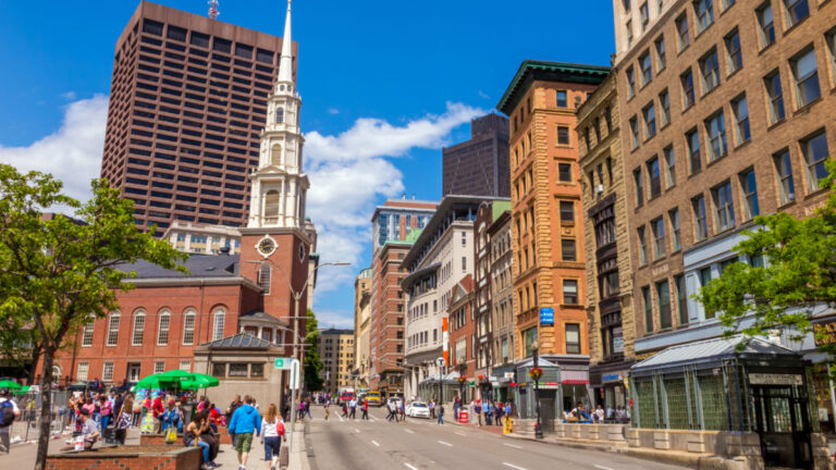 People walking down Boston's Freedom trail with the Park Street Church in the background