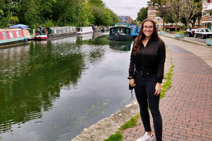 The author Brooke Horrobin posing near the river with boats in the background