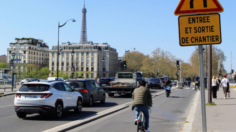 View of the traffic and the people wandering and cycling in the bustling street in Paris