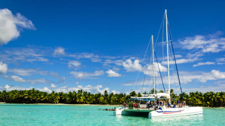 Tourists enjoying on the white catamaran on azure water against the blue sky