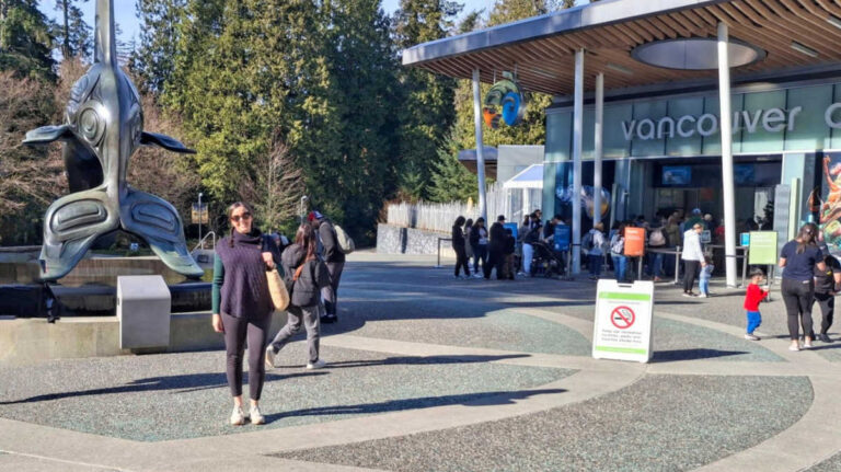 The author Catherine Driver posing for a photo outside the Vancouver Aquarium on a sunny day