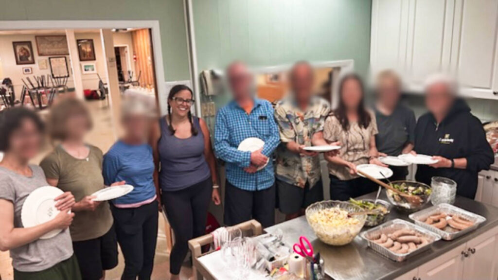 The author Catherine Driver and her Camino friends smiling for a photo with their dinner on the table