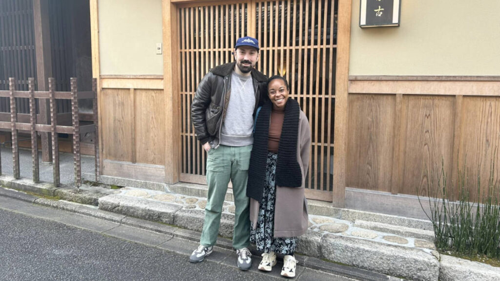 The author Chelsea Booker and her husband posing for a photo outside of Ryokan Motonago