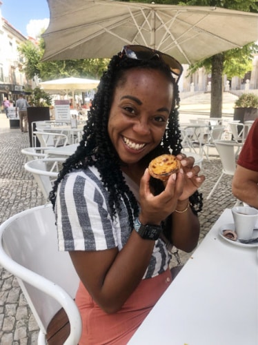 Chelsea Booker smiling while holding a pastry in Alcobaça, Portugal
