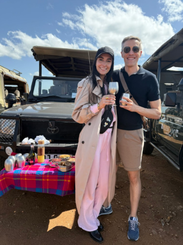 Travel Lemming founder Nate Hake and his partner Clara, toasting their glasses of drinks at the safari