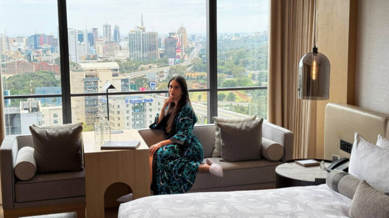Clara Kesseler posing for a photo in their room at JW Marriott Nairobi with a view on her background
