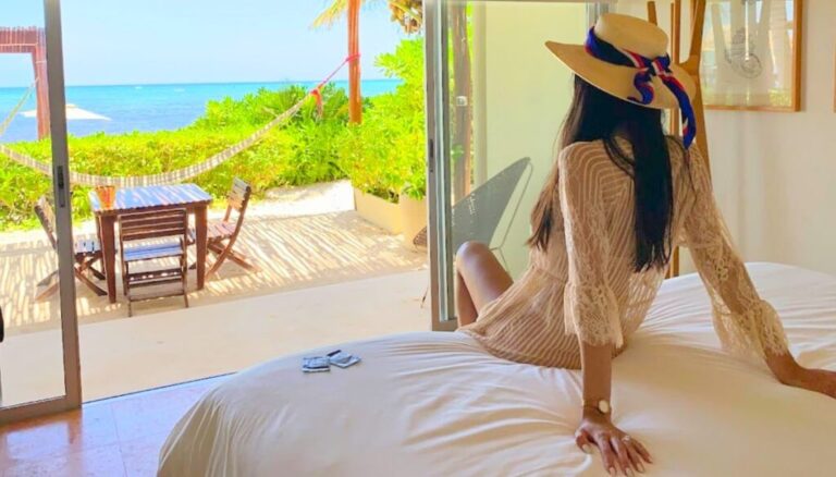 Clara sitting on the bed with the view of the ocean at Mereva