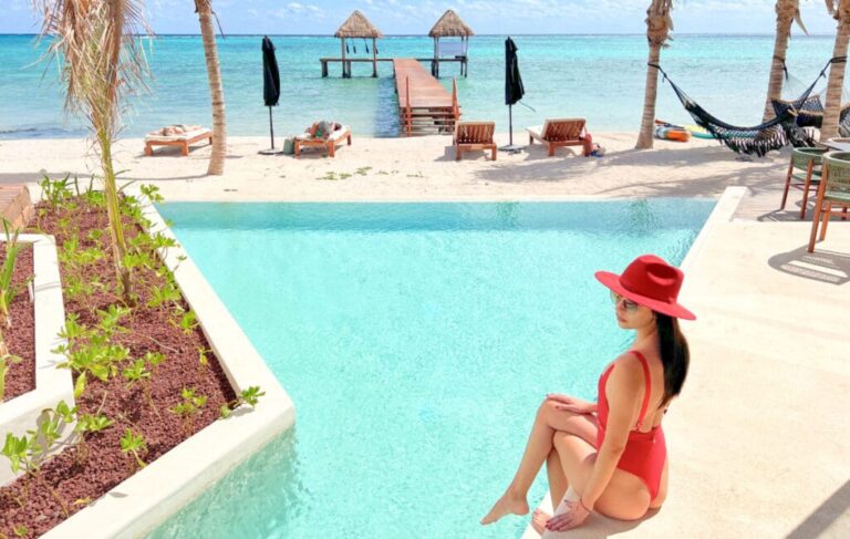Travel Lemming Writer Clara, posing for a photo on the edge of the pool at Nerea Hotel