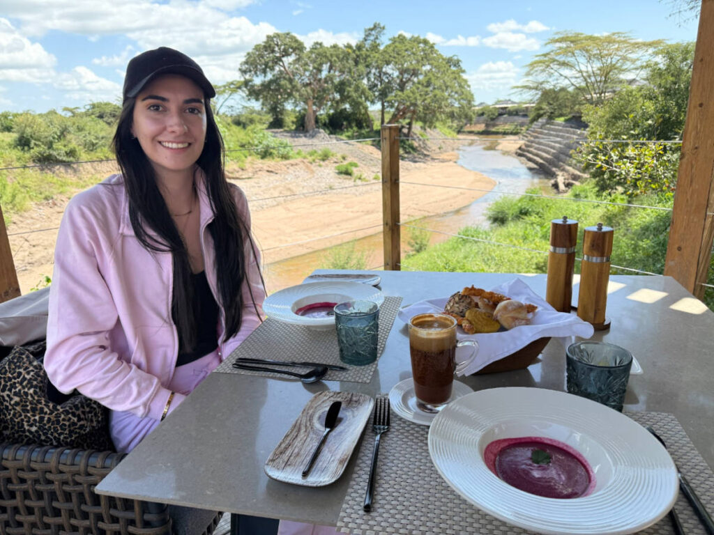 Travel Lemming writer Clara Kesseler, smiling for a photo with a breakfast spread outside the room