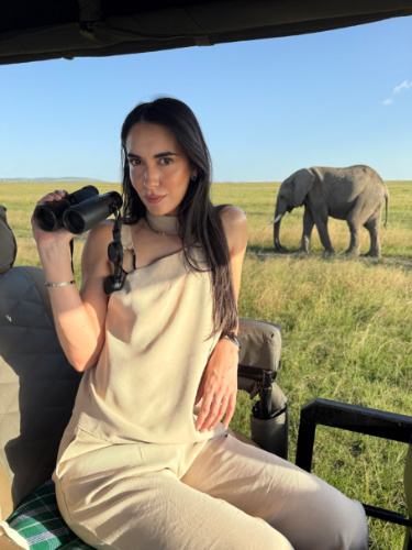 Travel Lemming writer Clara Kesseler, modeling her binoculars with the elephant in the background