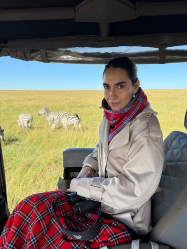 Travel Lemming writer Clara Kesseler, wearing the flannel scarves with a herd of zebras in the background