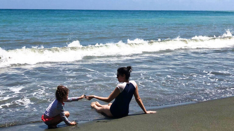 The author Claudicet Peña and her daughter enjoying at the shoreline of Dominican Republic