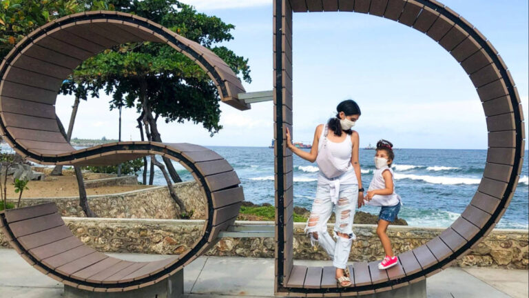 The author Claudicet Pena and her daughter standing on the tourist sign