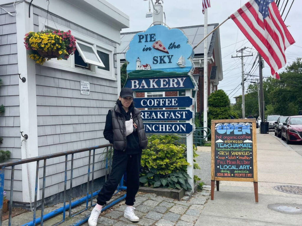 The author Claudicet Pena, posing for a photo at the entrance of Pie in the Sky Bakery & Cafe