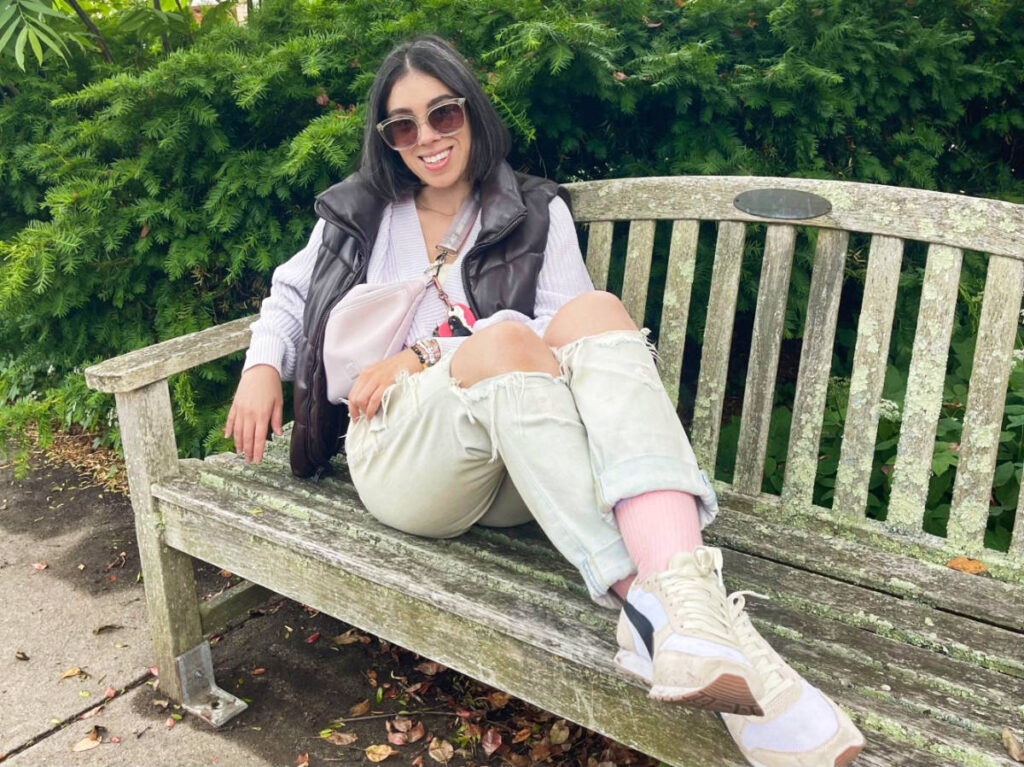 The author Claudicet Pena, posing for a photo on a bench in downtown Falmouth