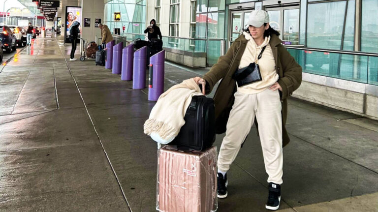 The author Claudicet Pena, posing for a photo with her luggage at the Boston Logan International Airport, Combat Airport Anxiety