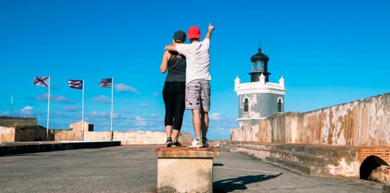 A couple under the clear blue sky in Castillo San Felipe del Morro