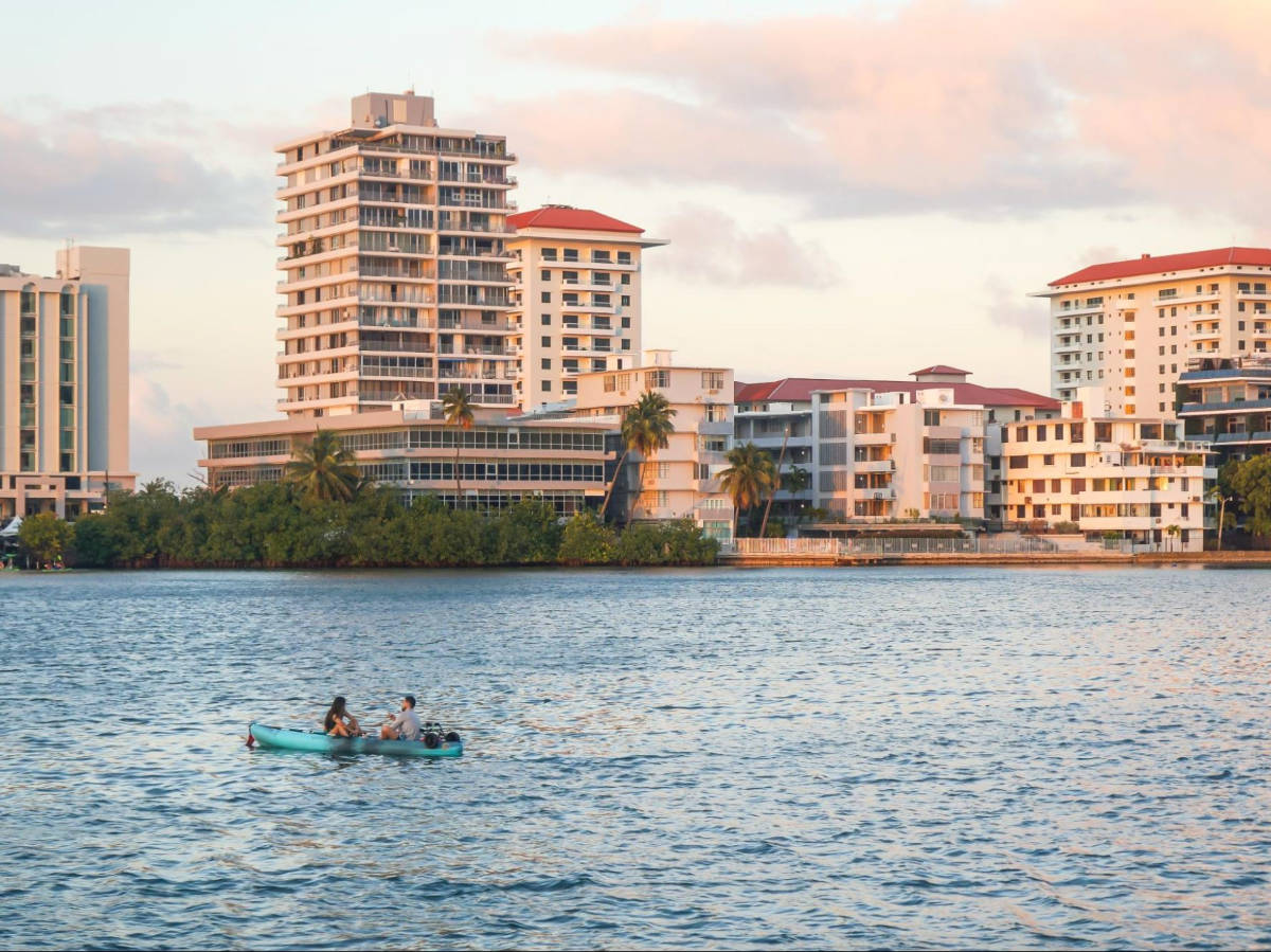 A couple kayaking with skyline views in Condado at sunset