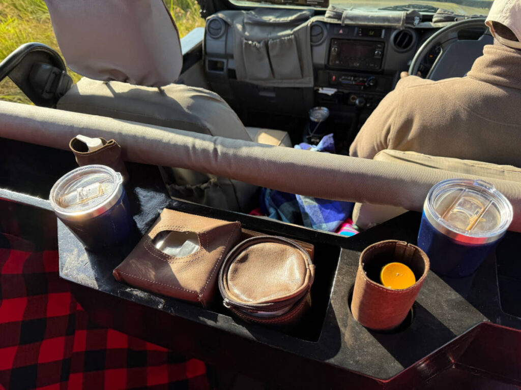 A custom holder of coffees, sunscreen, tissues, and sanitizer in the safari vehicle