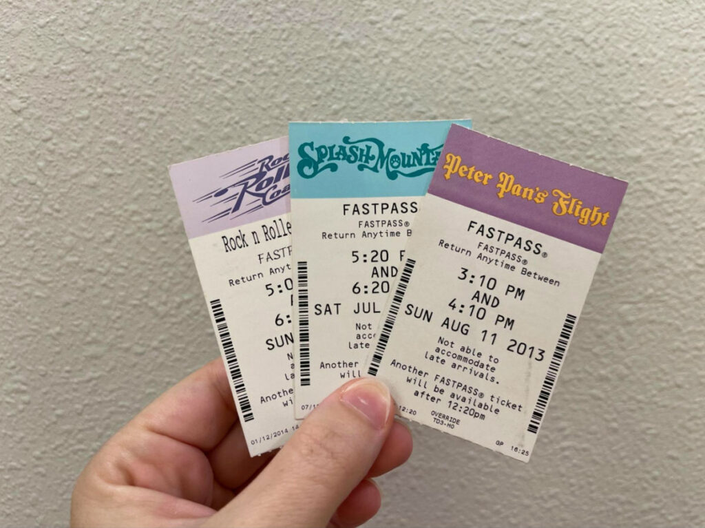 Holding three Disney FastPasses to different rides
