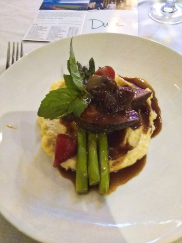 A plate with mashed potatoes topped with duck meat