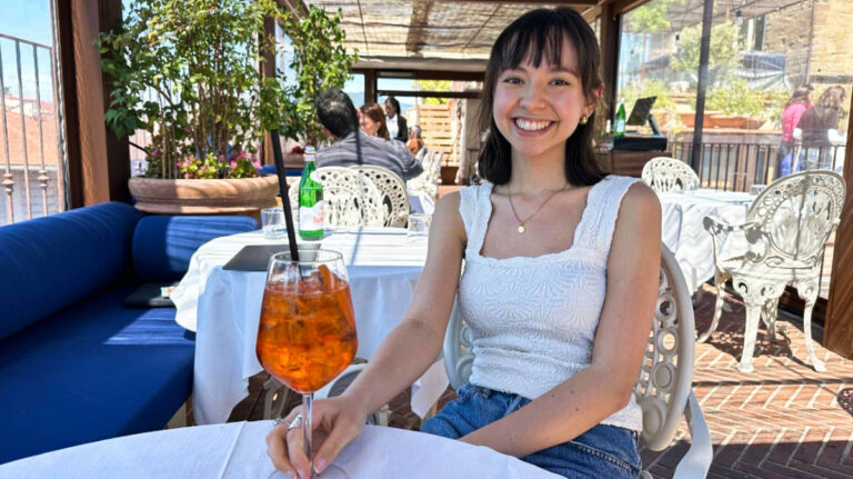 Travel Lemming Editor, Lea Rose, holding a glass of drink at Angel Roofbar & Dining