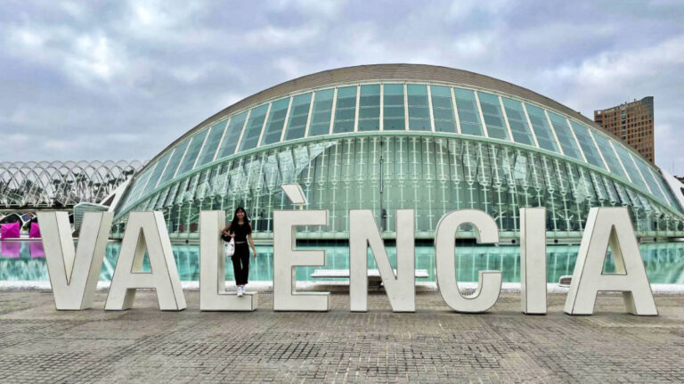 Travel Lemming Editor, Lea Rose Allbaugh, posing for a photo at the signage of VALENCIA