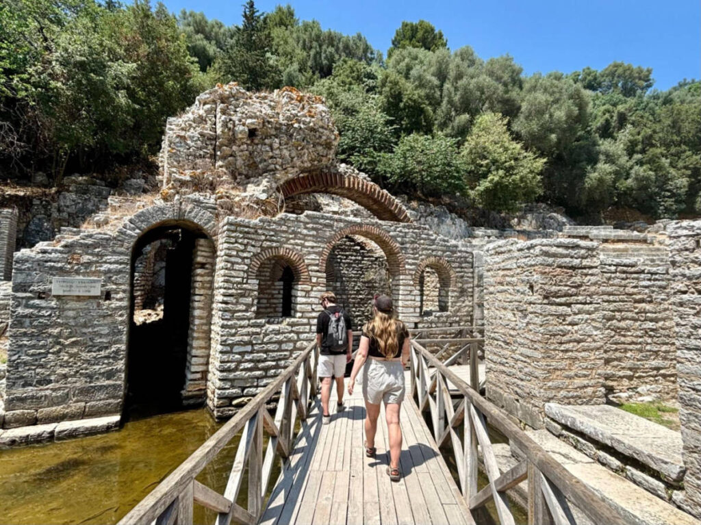 People walking along the boardwalk leading to the ruins