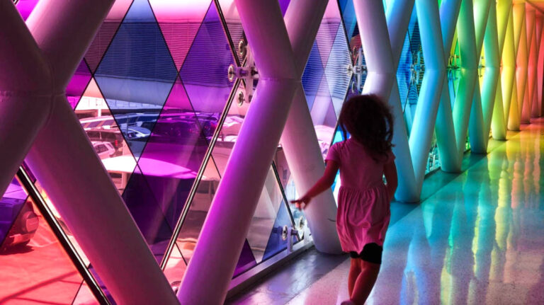 The author Claudicet Pena's daughter running along the colorful windows of Miami International Airport