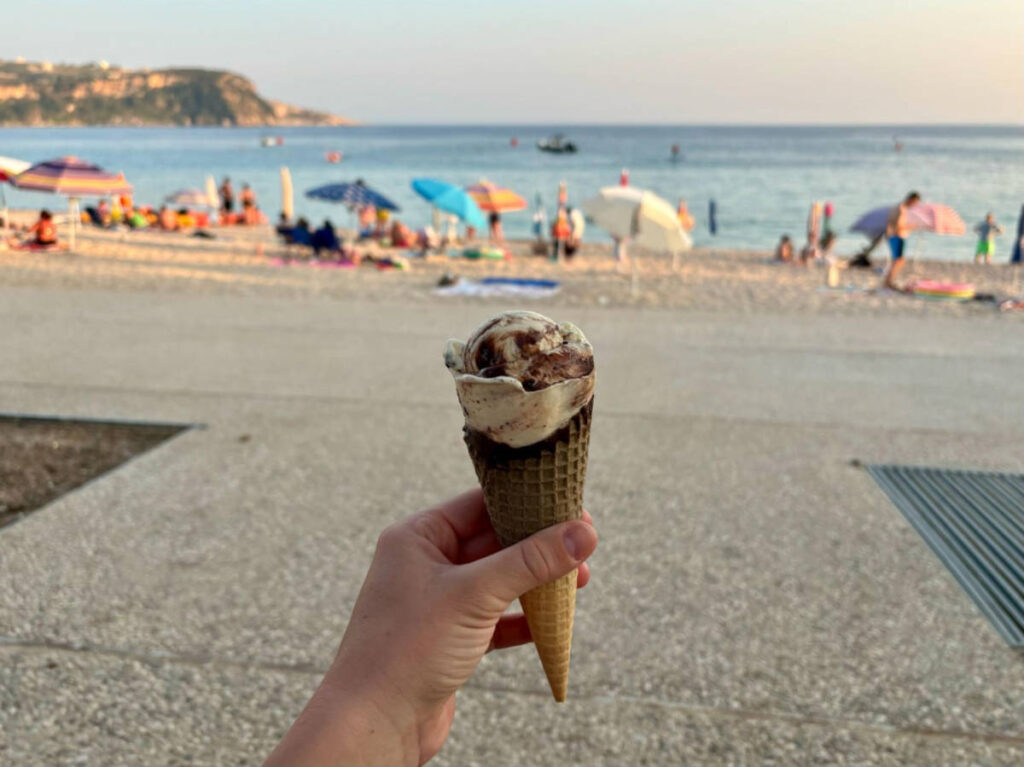 Holding a cone of ice cream at the beach